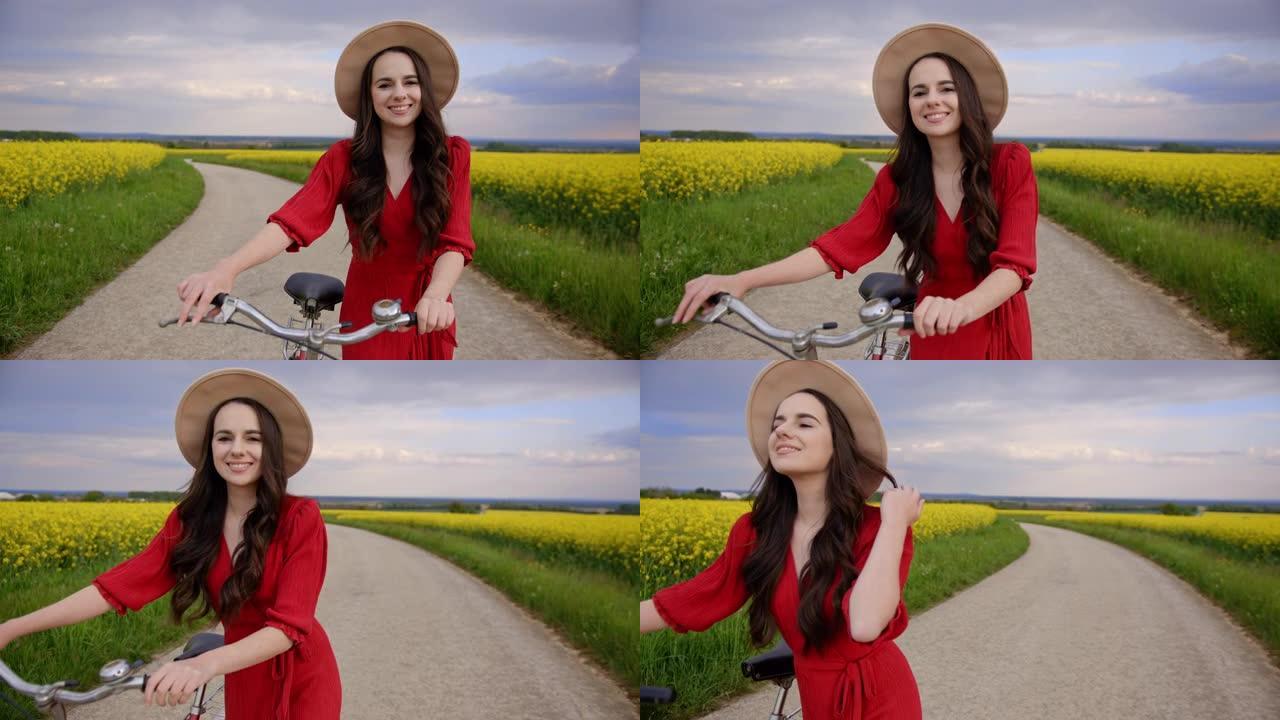 追踪，一个穿着红色连衣裙的黑发女人的中景照片，她骑着自行车穿过黄色的金鱼龙花，慢动作