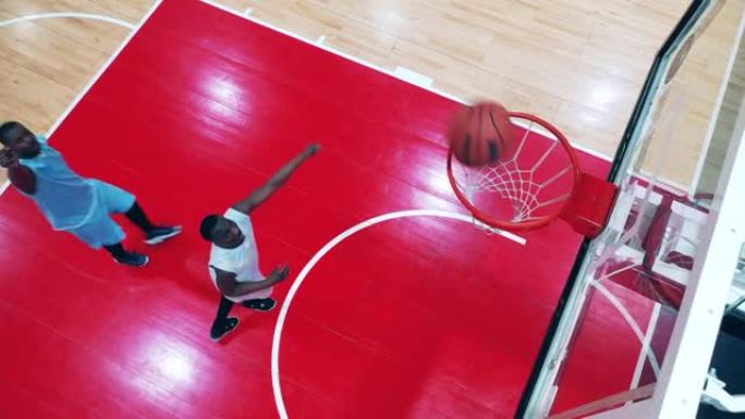 两名非裔美国球员在健身房进行篮球练习的俯视图