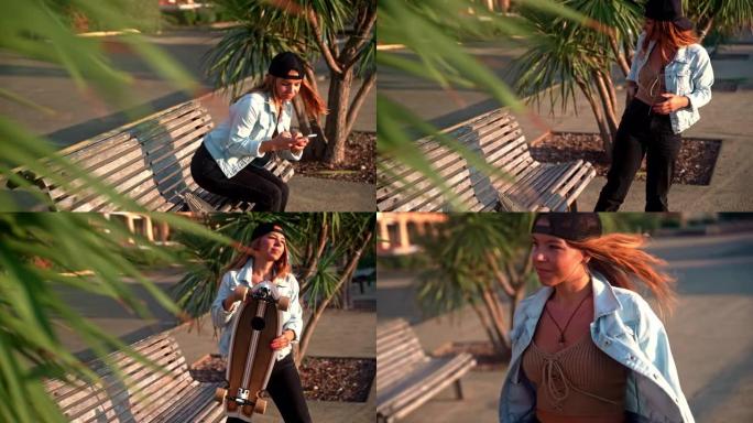 棕色头发的年轻女子坐在木板路上的长凳上，用手机站起来，拿着滑板走开