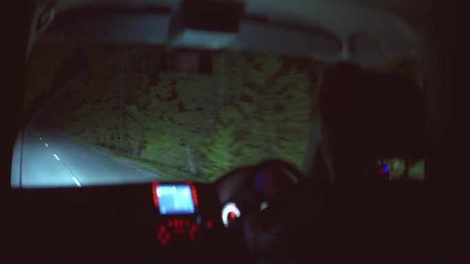男人晚上在森林里开车。变形镜头拍摄
