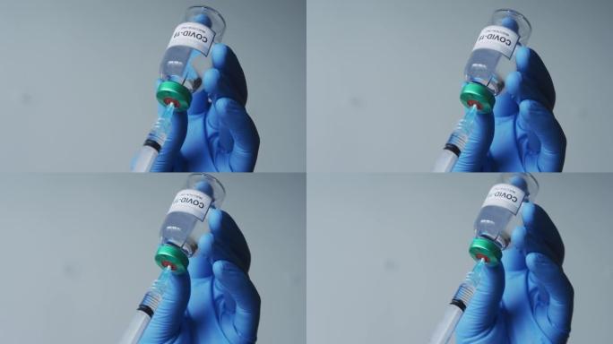 白人男性医生戴着防护手套，用新型冠状病毒肺炎疫苗填充注射器