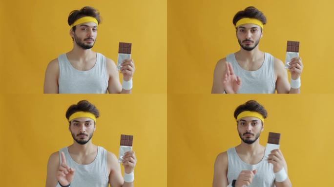 严肃的阿拉伯运动员闻到巧克力的肖像，然后在黄色背景上对糖说不