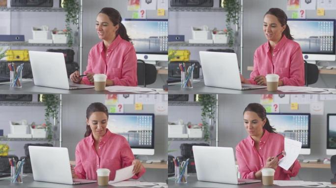 办公室里的女商人在笔记本电脑上的办公桌上进行视频通话，向客户展示设计