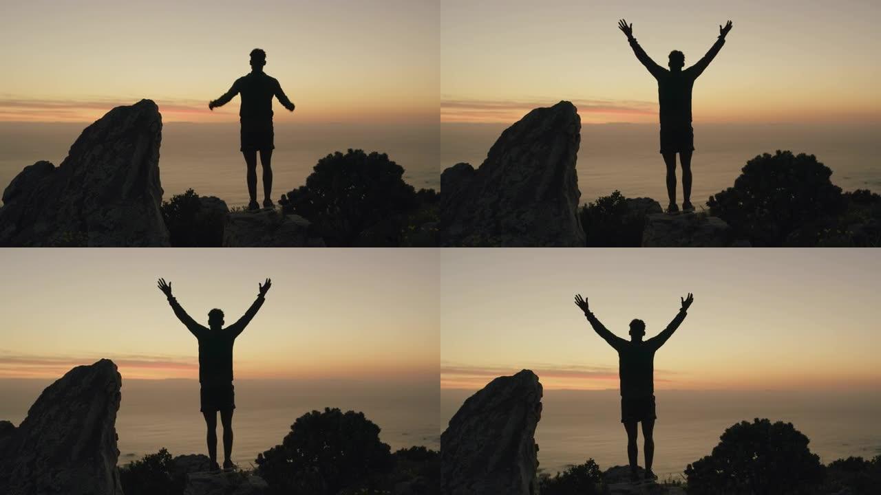 4k视频片段，男子在山上伸出双臂站着