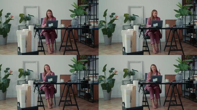 快乐成功美丽的女办公室经理使用笔记本电脑在线咨询客户。网络会议概念。