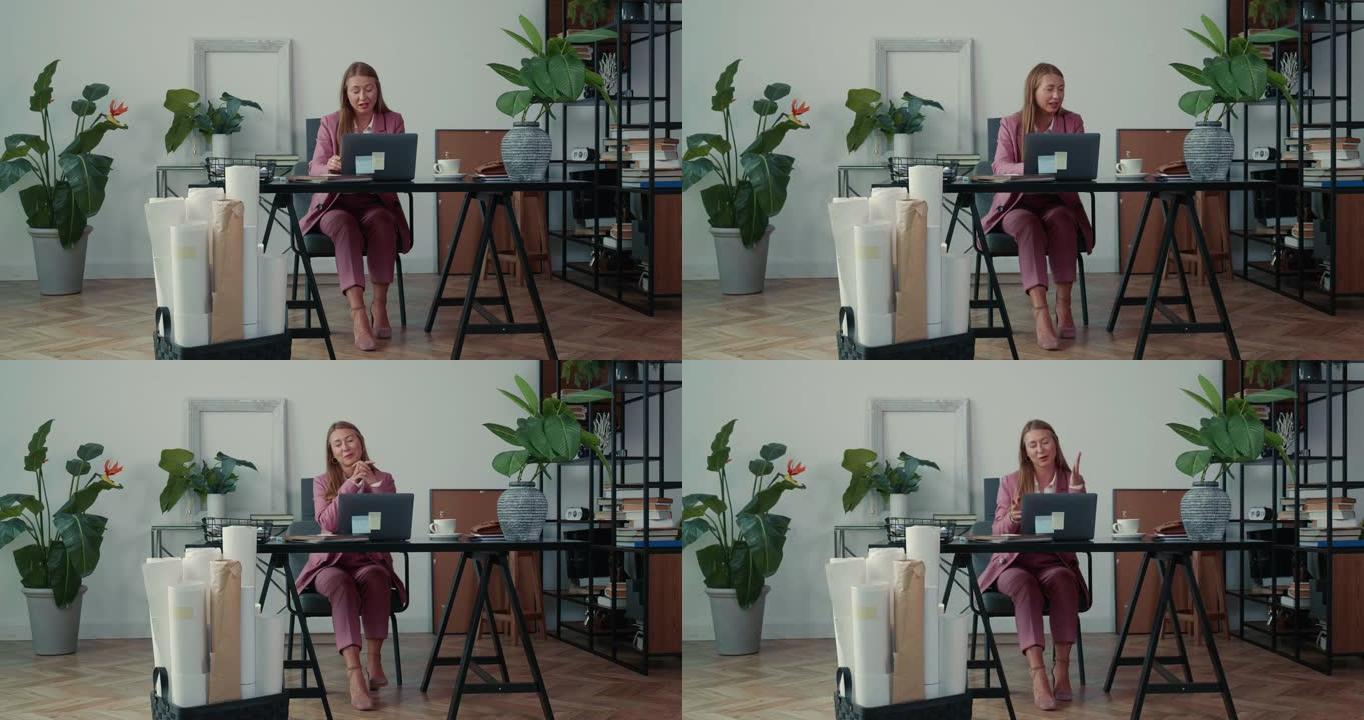 快乐成功美丽的女办公室经理使用笔记本电脑在线咨询客户。网络会议概念。