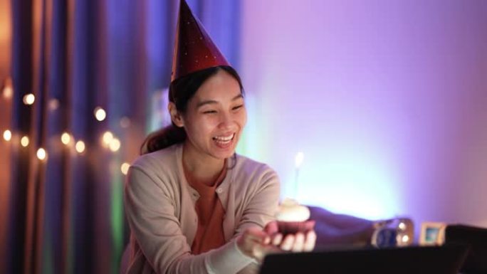 亚洲妇女通过笔记本电脑上的在线视频会议与朋友庆祝生日