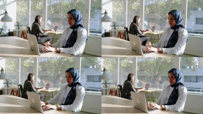 中东女商人带着头巾在启动工作区的笔记本电脑上工作