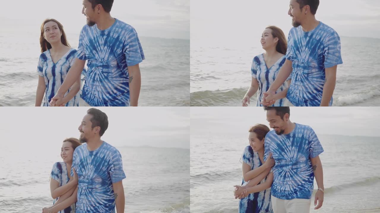 年轻的亚洲夫妇在海滩上周末穿扎染。