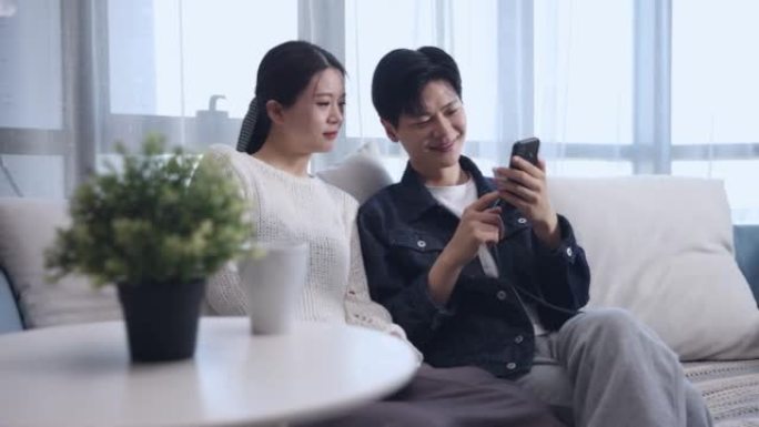 年轻夫妇一起用手机分享社交媒体