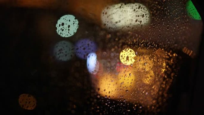 在傍晚的城市交通中，从潮湿的车窗拍摄的摘要。绝望，乏力，孤独的概念。多雨的秋天天气。慢动作4K