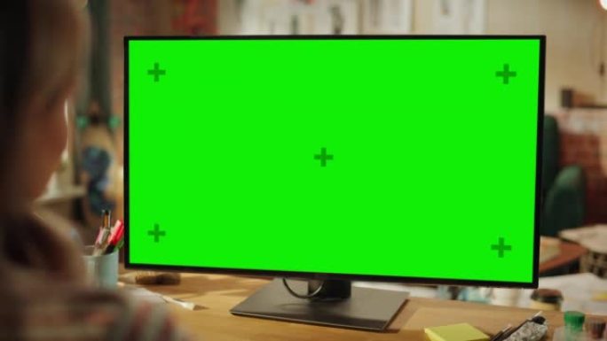 在专业自由职业者的肩膀上，在家中使用绿色样机屏幕个人计算机。女性类型，通过互联网浏览，使用计算机