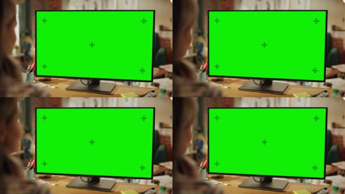 在专业自由职业者的肩膀上，在家中使用绿色样机屏幕个人计算机。女性类型，通过互联网浏览，使用计算机