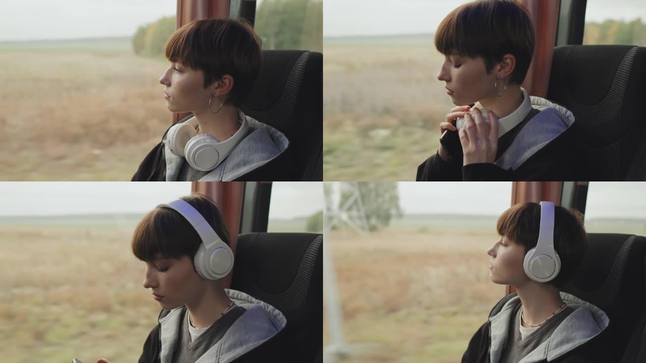 戴着耳机的少女坐在公共汽车的窗户旁
