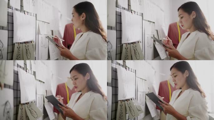 时装设计师用墙上的素描纸在她的数字平板电脑上素描服装