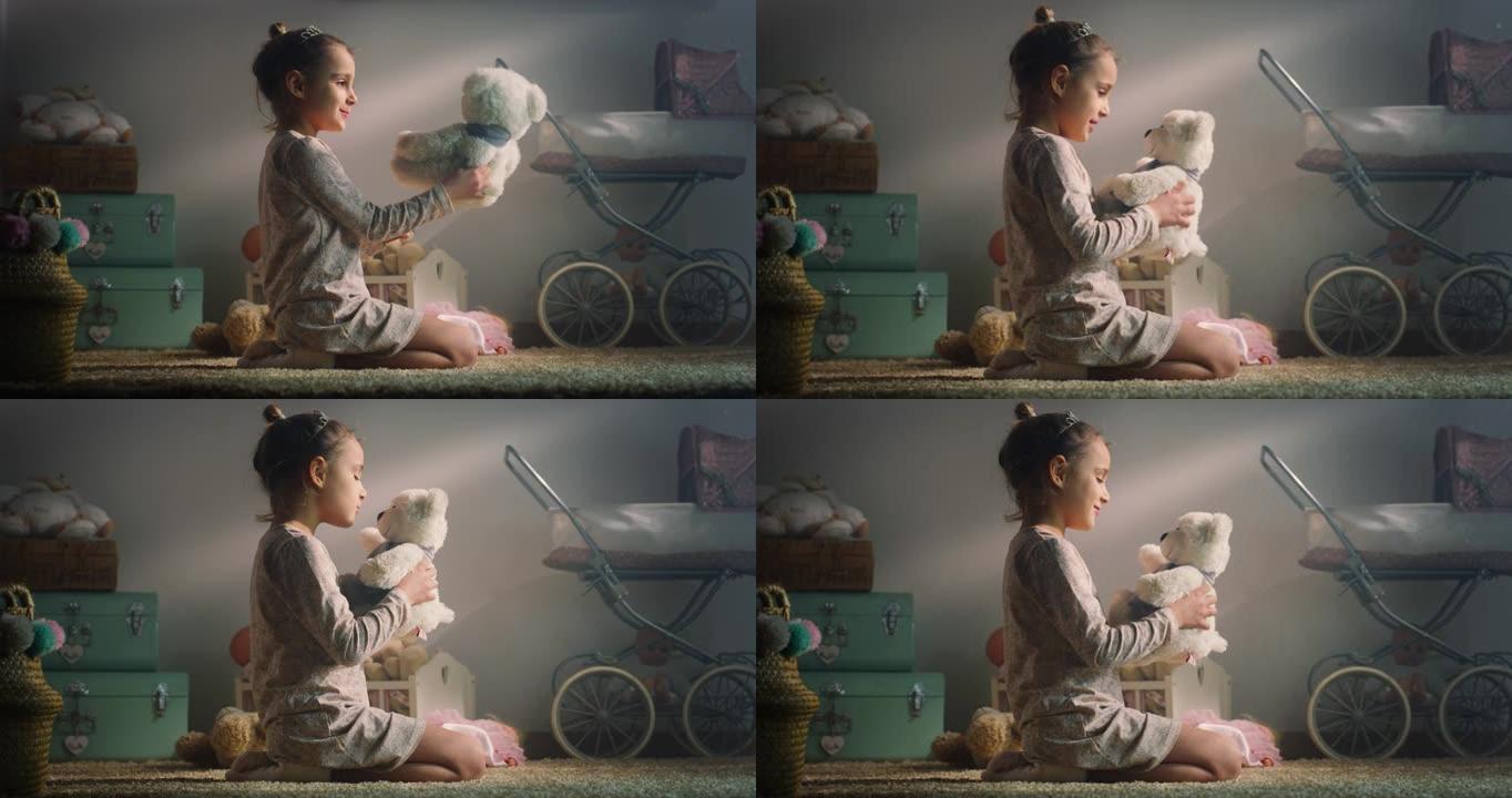 穿着睡衣的小女孩的电影镜头正在向她的泰迪熊讲述一个神奇的童话故事，并坐在托儿所的地毯上拥抱它。爱情、