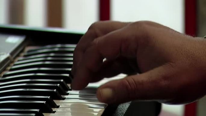 一个玩电钢琴的人的手。特写。