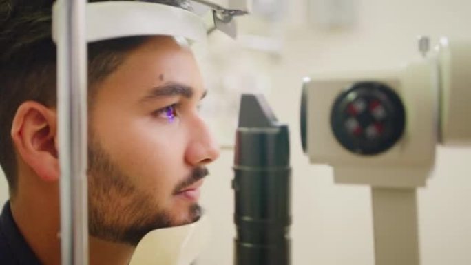 验光师在诊所对病人做眼部检查。配镜师用眼压计机器评估一个年轻人的视力。眼部护理专业人员使用处方镜片帮
