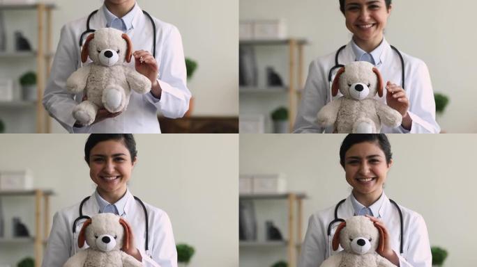 印度儿科医生拿着蓬松的玩具微笑看着相机