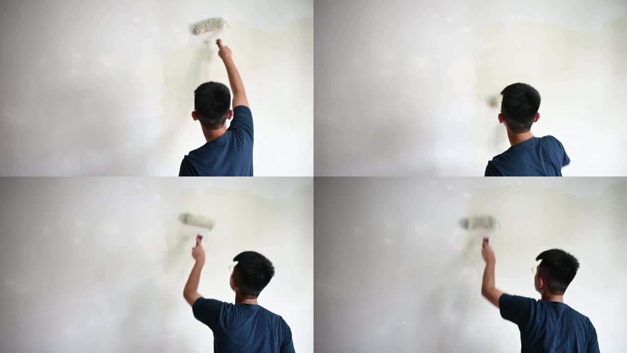一个亚洲中国十几岁的男孩在日落时画他的卧室，公寓装修