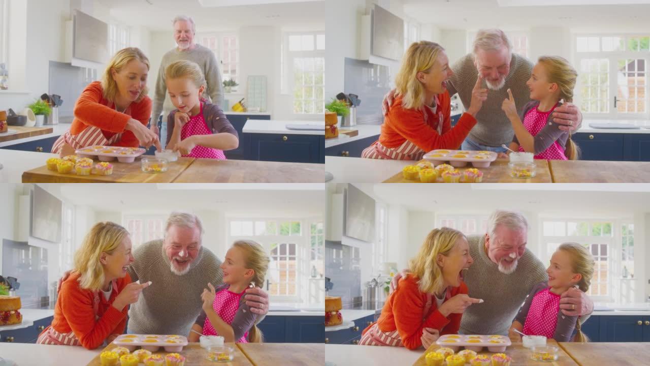 祖父母和孙女在厨房柜台上装饰自制蛋糕很开心
