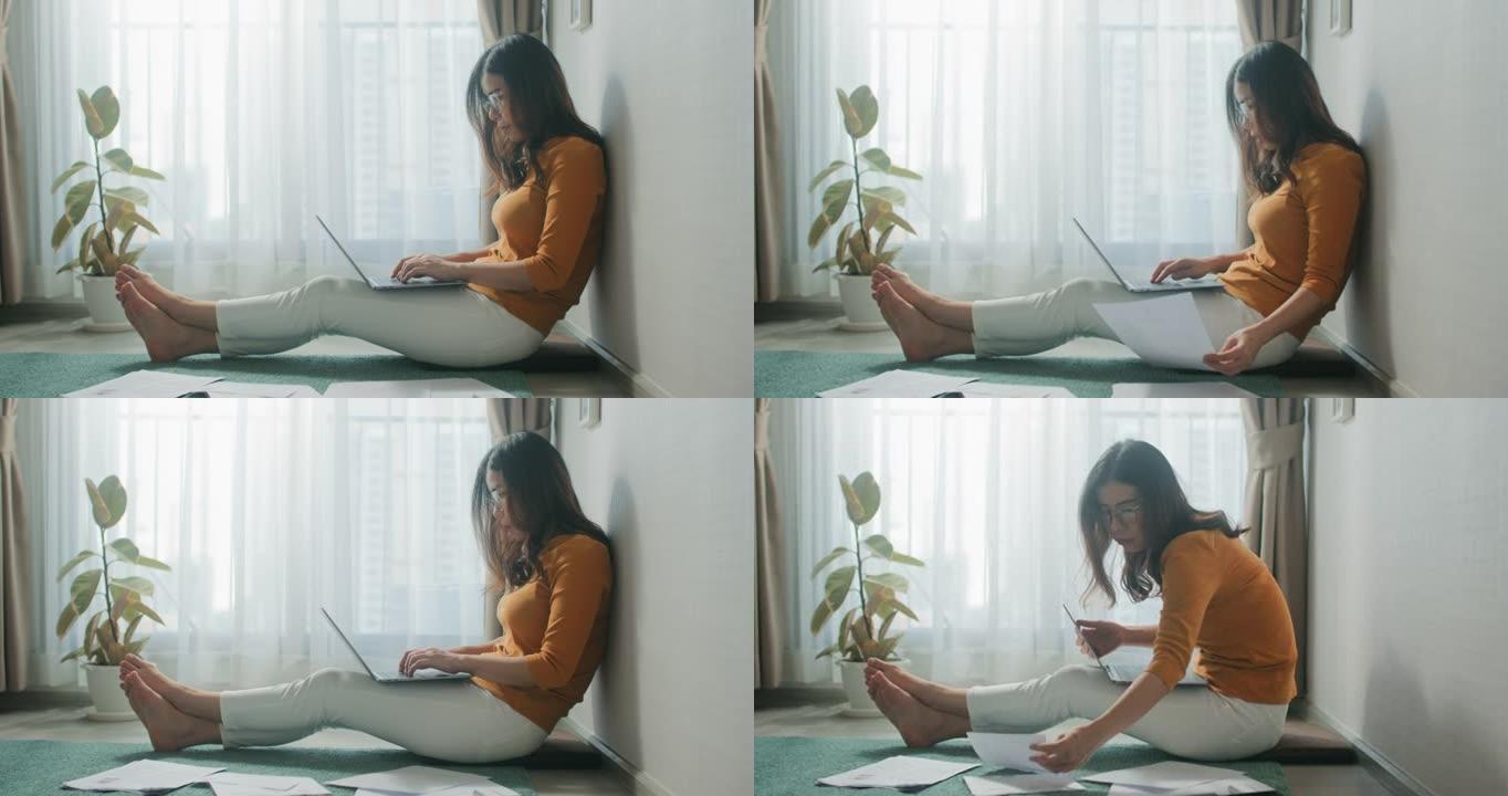 在家中使用笔记本电脑，坐在地板上的女人处理文件，文件，头脑风暴研究创意项目。阳光客厅的生产性工作