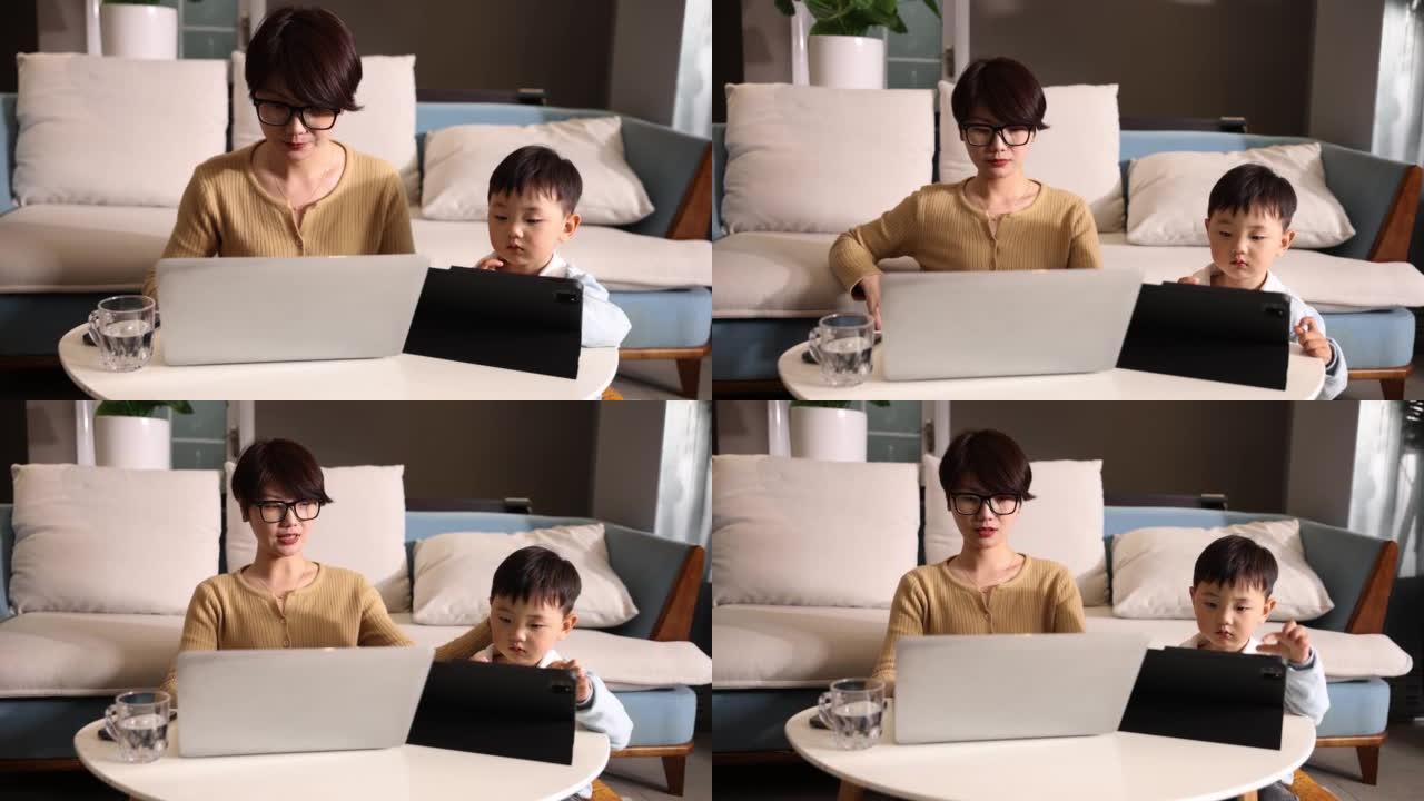 母亲和儿子一起在家工作，一起使用平板电脑