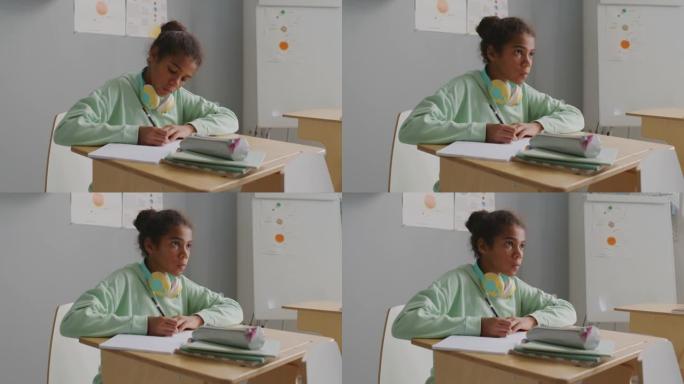专注的女孩在上课时在笔记本上写作