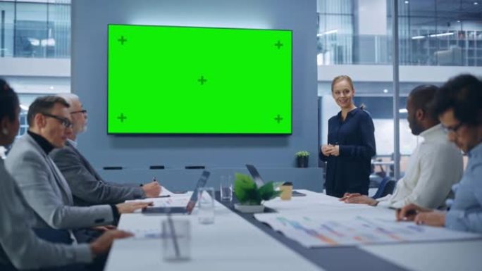 办公室会议室会议演示: 美丽的女商人谈话，使用绿屏色键墙电视。数字企业家向多民族投资者群体展示电子商