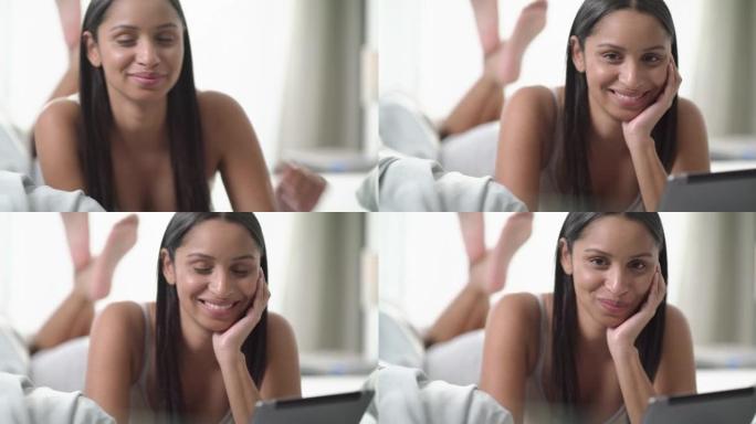 一名年轻女子在家中床上使用数字平板电脑的4k视频片段