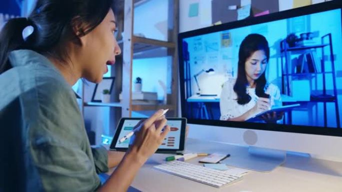 亚洲女商人使用桌面与同事谈论客厅视频通话会议的计划。