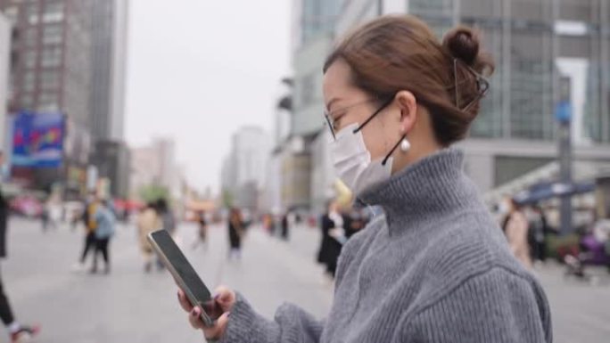 亚洲女子戴口罩行走都市