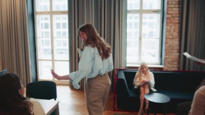 镜头跟随女执行经理进入大办公室，由团队同事走着，坐在桌子旁慢动作。