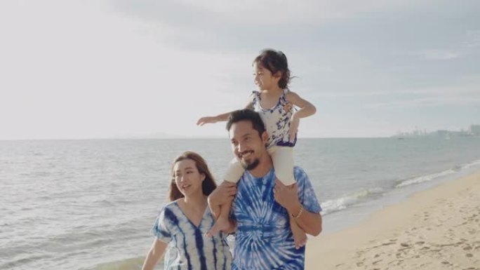 幸福亚洲家庭和女儿在海滩上。