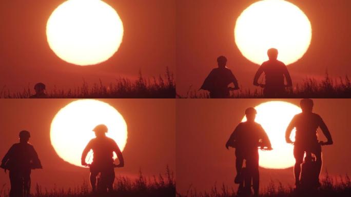 日落时两名骑自行车的人骑山地自行车的剪影