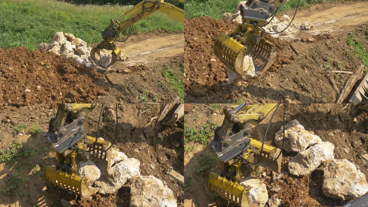 特写: 挖掘机操作员将大石头从一堆转移到排水坑。