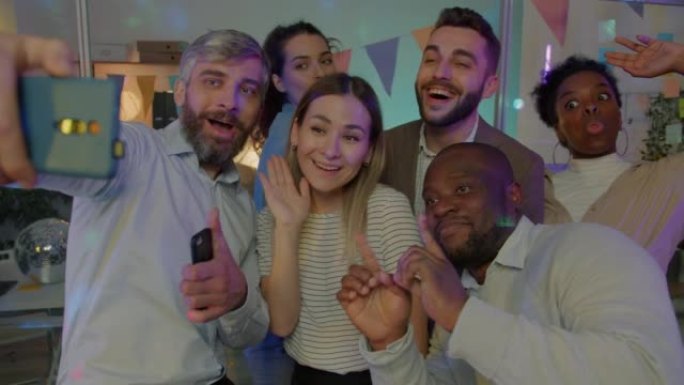 快乐的商业团队在愉快的派对中为智能手机相机拍照和跳舞拍照