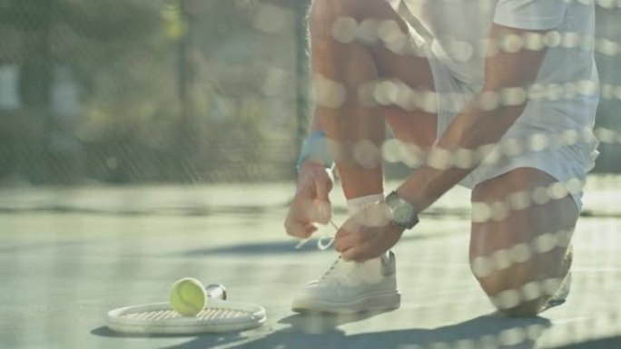 成熟的网球运动员弯腰将鞋带绑在网球场上