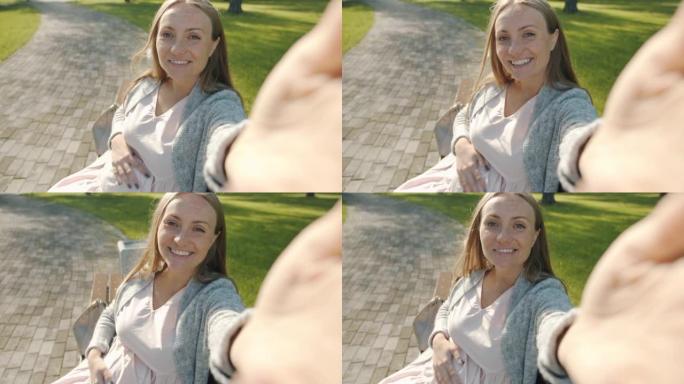 在户外在线视频通话中，快乐孕妇聊天和触摸腹部的POV肖像