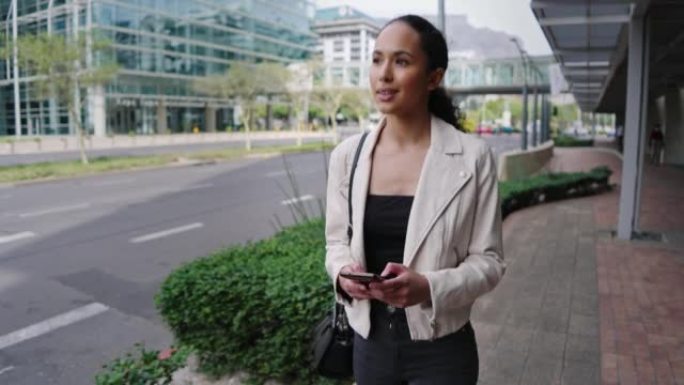 一位年轻的混血女商人在手机上发短信，在城市散步。自信的雄心勃勃的企业家在上下班途中浏览应用程序和社交