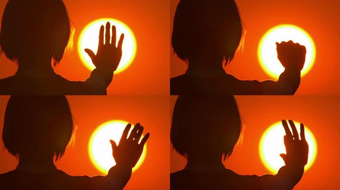女人 (剪影) 站在明亮的太阳和天空背景下。特写