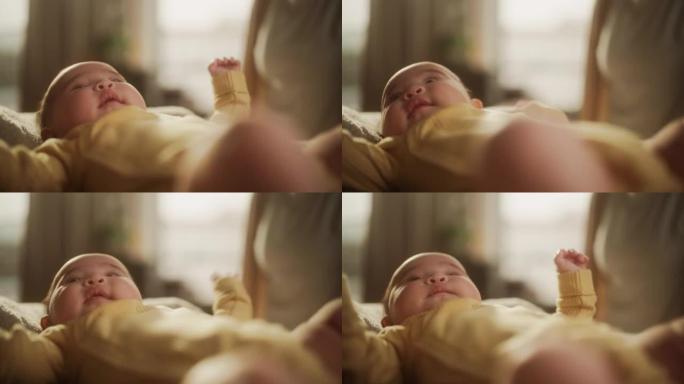 一个可爱的亚洲婴儿躺在婴儿床里的肖像，周围是柔软的毯子。活跃的婴儿在温暖的早晨阳光下醒来，环顾四周，