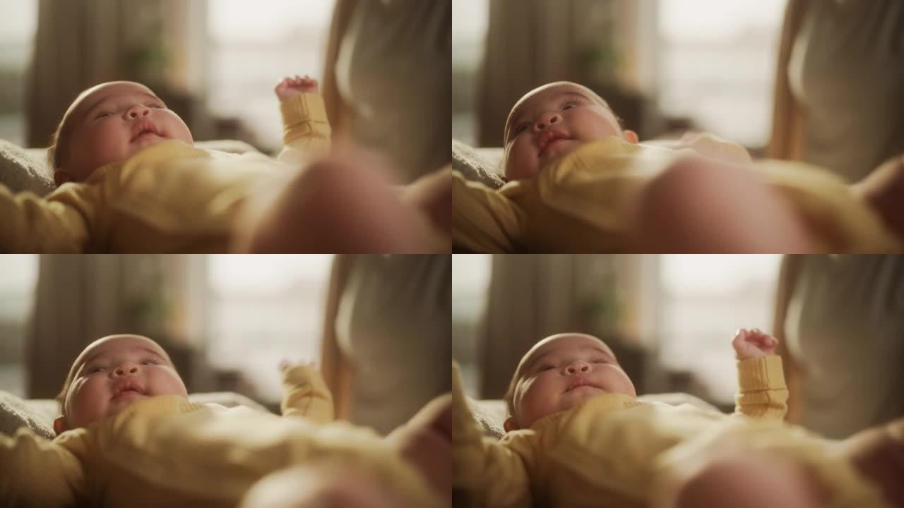 一个可爱的亚洲婴儿躺在婴儿床里的肖像，周围是柔软的毯子。活跃的婴儿在温暖的早晨阳光下醒来，环顾四周，