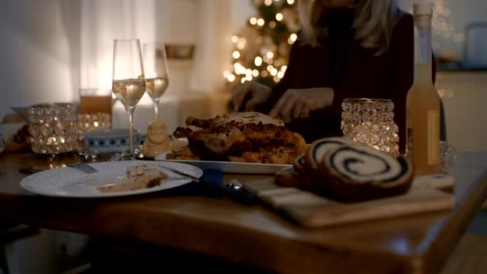 女人在圣诞节期间在餐桌上吃烤鸡