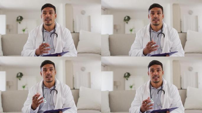快乐的西班牙裔男性医生在家里接受病人采访的肖像