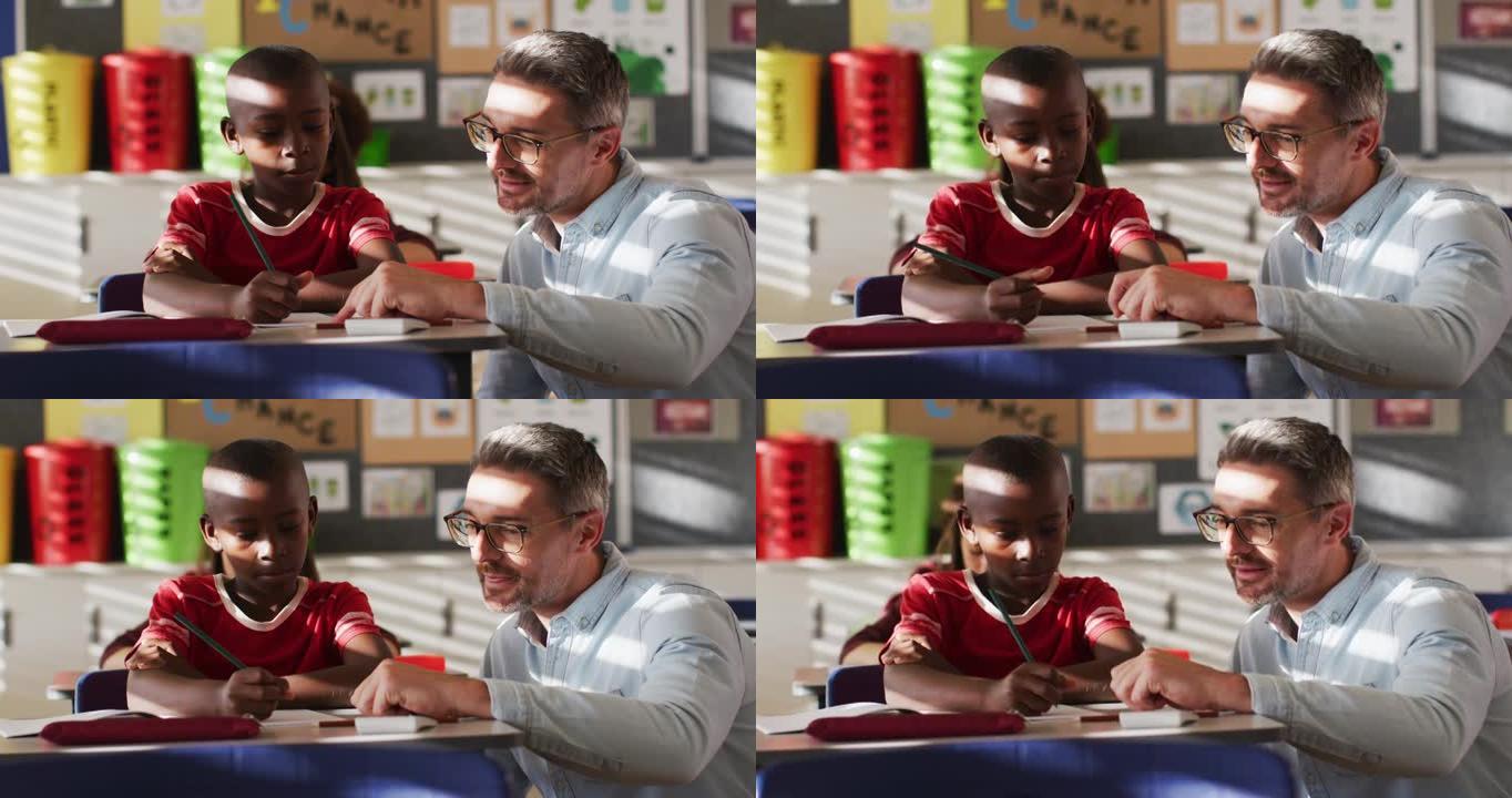 多元化的快乐男老师在学习过程中帮助坐在教室里的男生