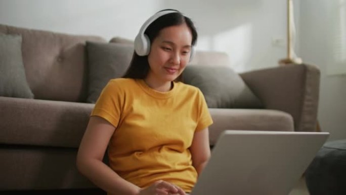 女人在家使用带耳机的笔记本电脑