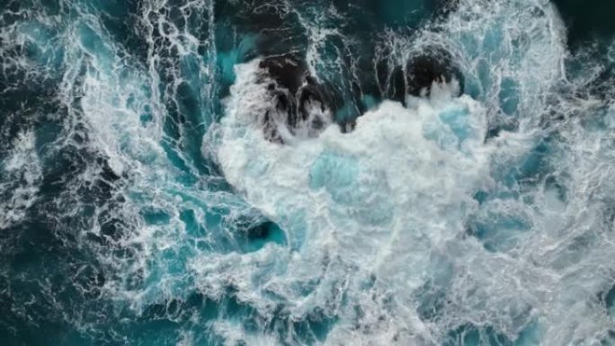 海洋或海洋大暴风雨冲浪清澈的绿松石水，泡沫白色质地。强波撞击的慢动作航拍