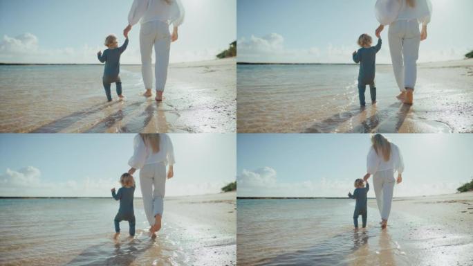 母亲和年幼的婴儿在沙滩上散步