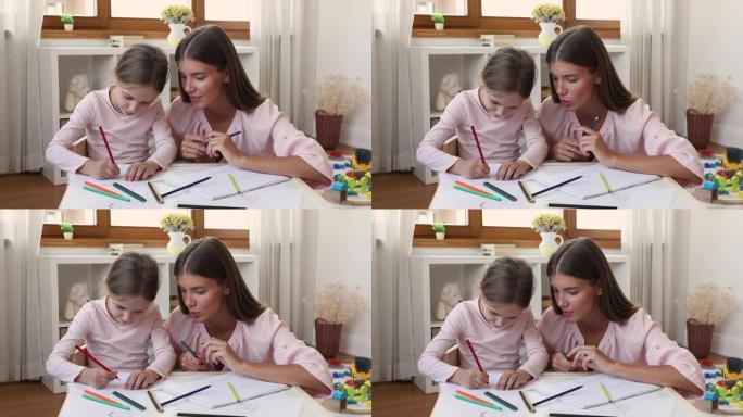 母亲和小女儿拿着彩色铅笔一起画画
